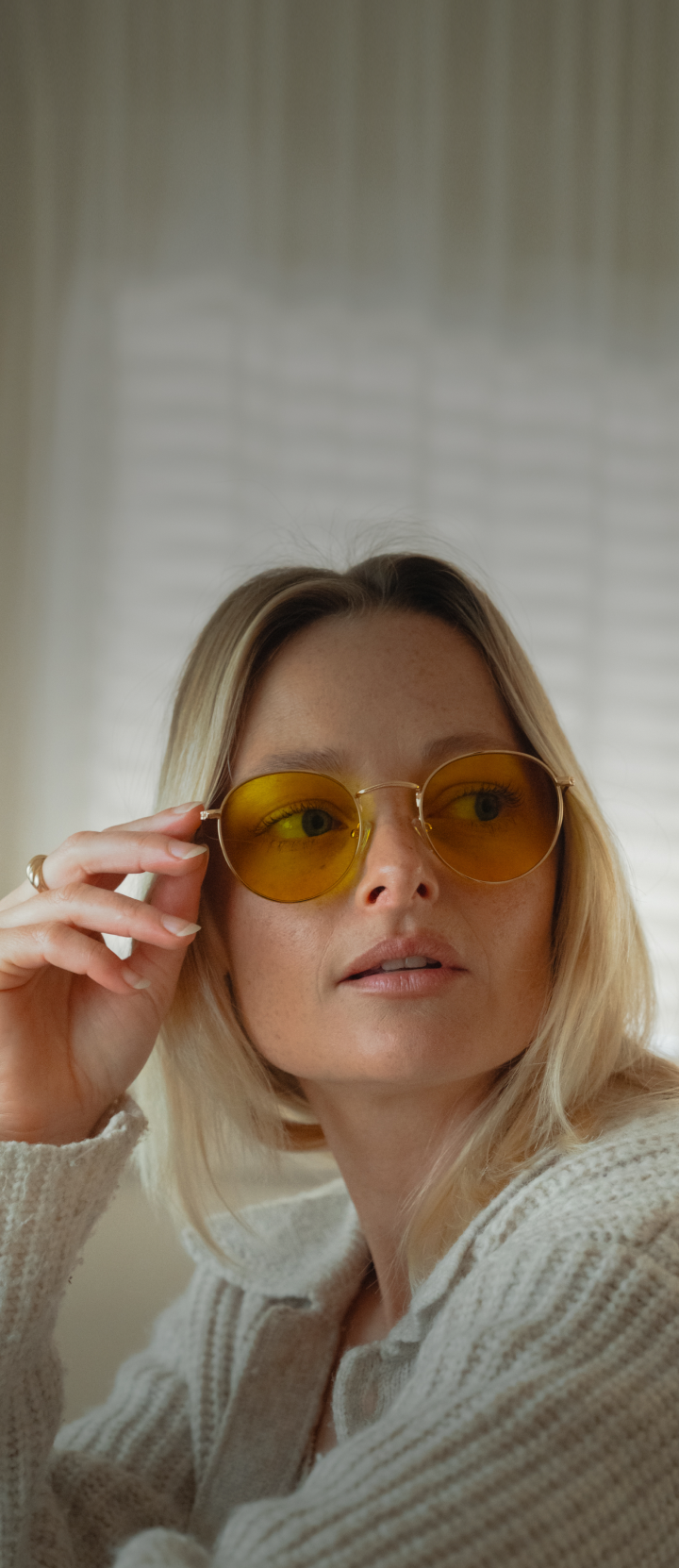 Person wearing yellow-tinted sunglasses, looking to the side.