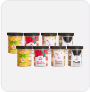 Seven ice cream tubs with various fruit and vanilla flavors on a black background.