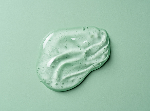 Clear gel blob on a green surface.