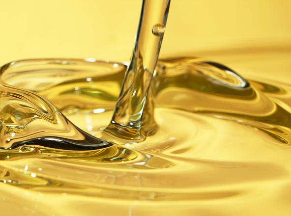 Close-up of golden liquid being poured, creating smooth ripples.