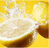 Sliced lemon splashing in water against a yellow background.
