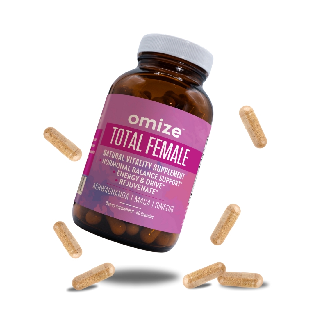 A bottle of Omize Total Female supplement with several capsules floating around it on a white background.