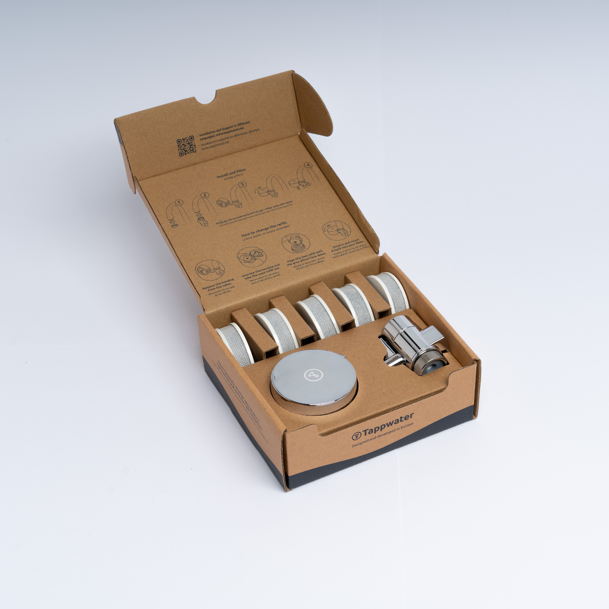 Open cardboard box with water filter components and instructions.