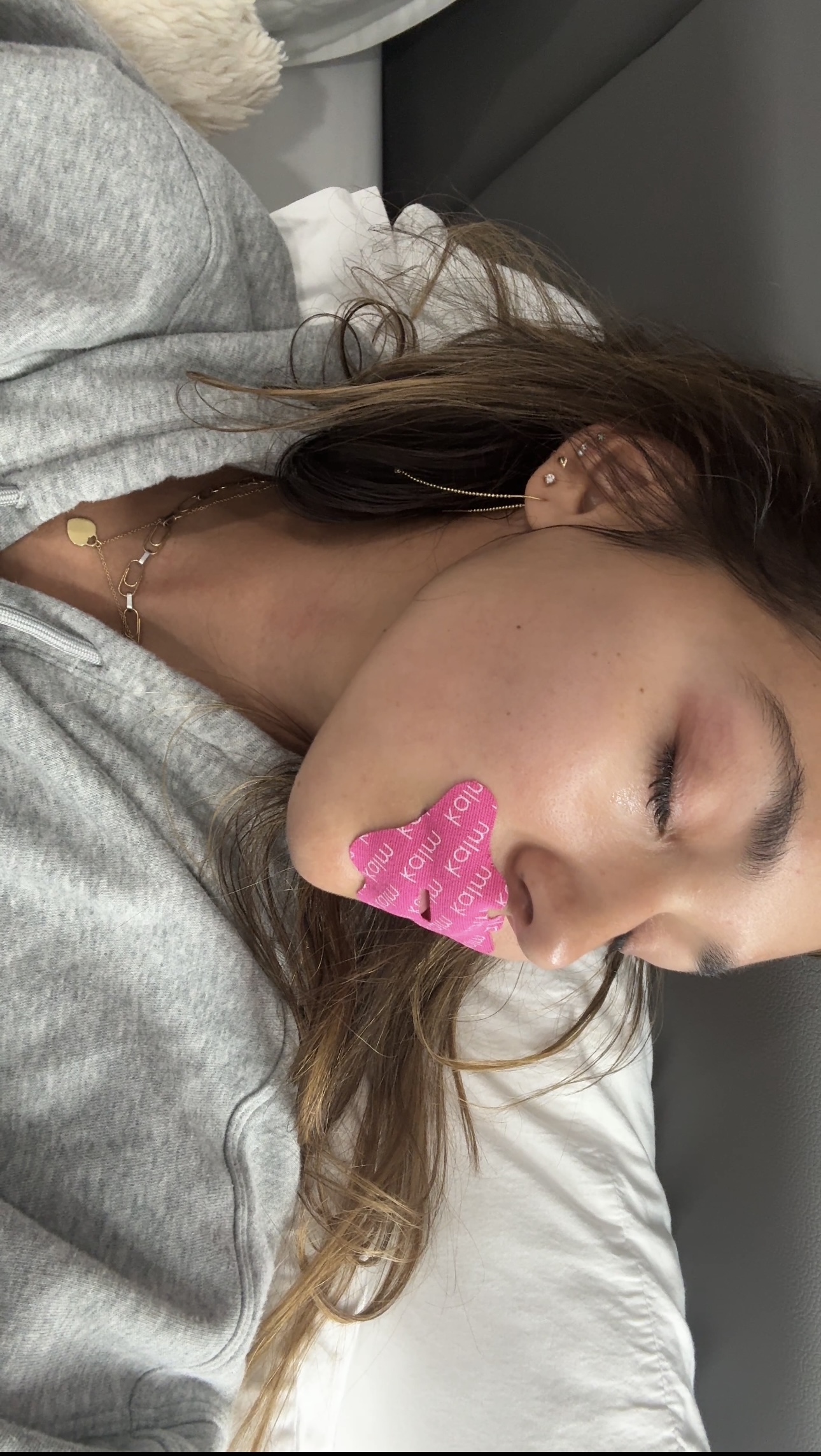 Person lying down with pink heart-shaped patch on lips.