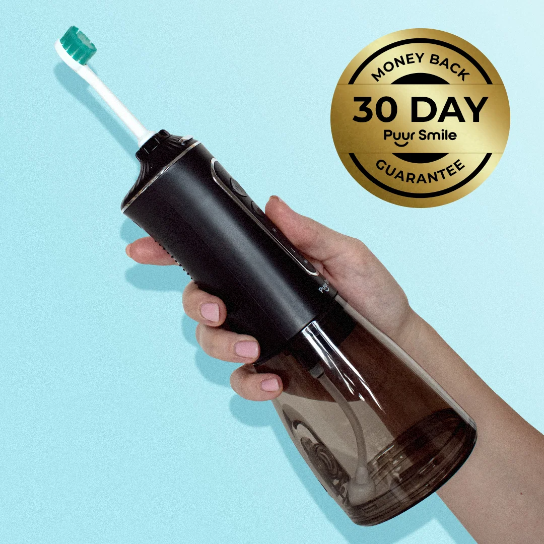 Hand holding a black Puur Smile electric toothbrush against a blue background with 30-day guarantee seal.