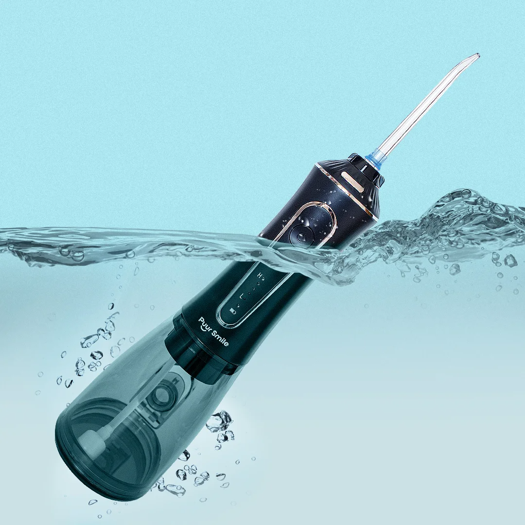 Electric water flosser partially submerged in water against a light blue background.