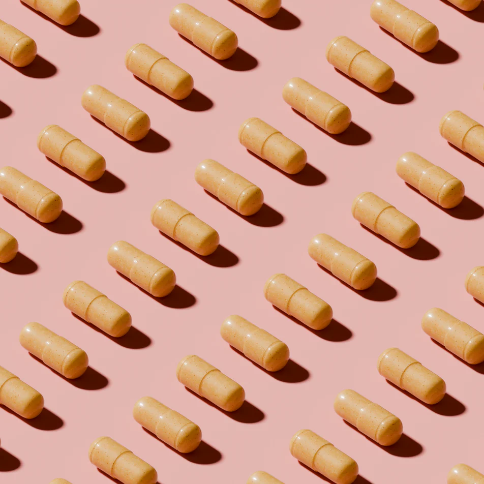 Pattern of yellow capsules on a pink background.