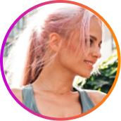 A smiling woman with pink hair tied back, shown in a circular frame with a colorful gradient border.