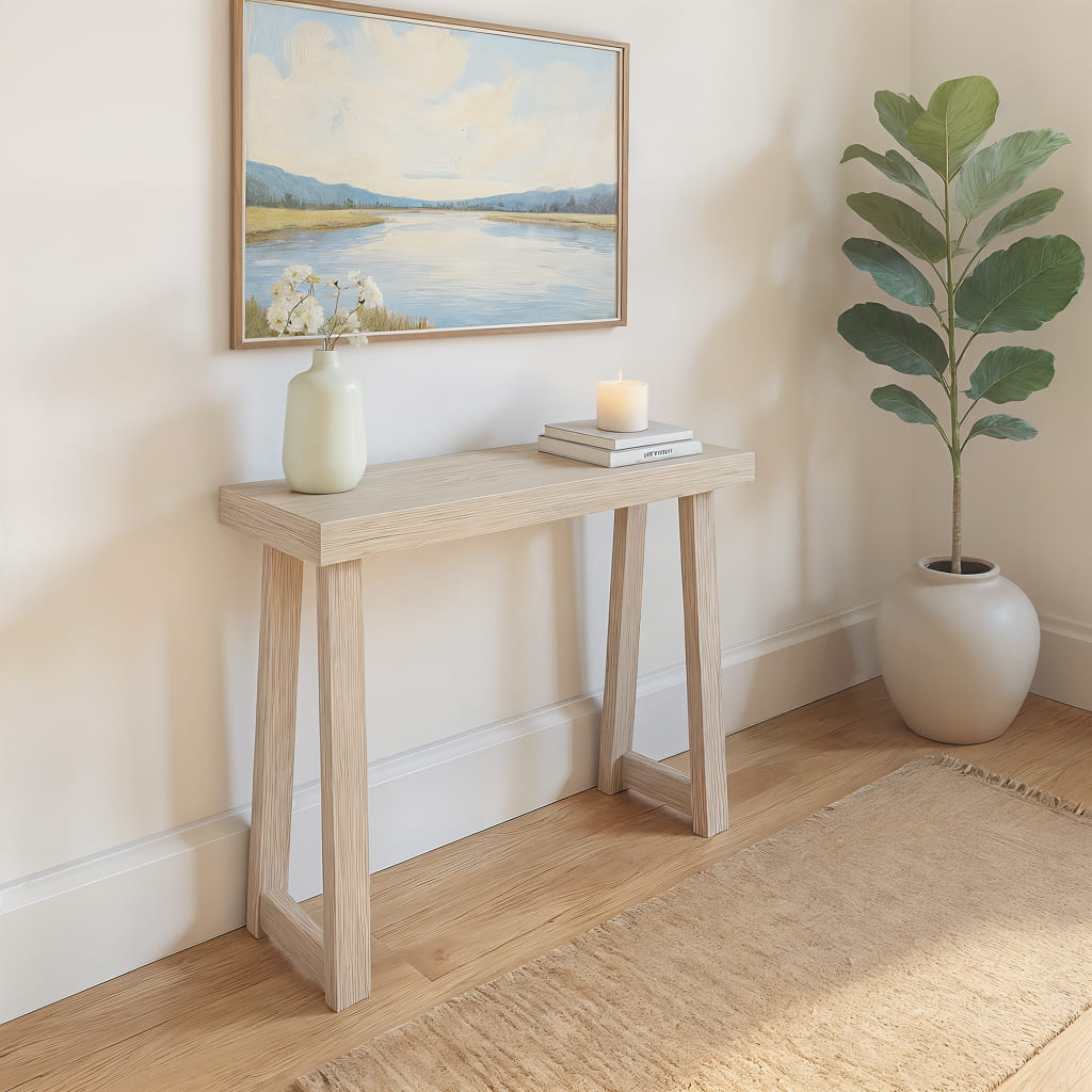 Blonde entryway table beneath ocean painting in living room.