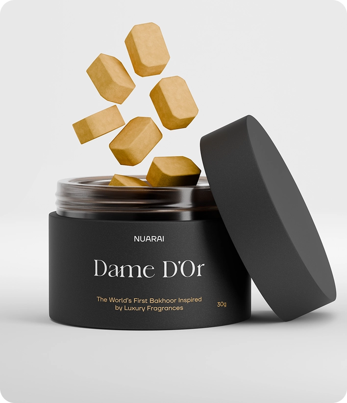 برطمان أسود مكتوب عليه "Dame D'Or" مع مكعبات ذهبية عائمة فوقه.