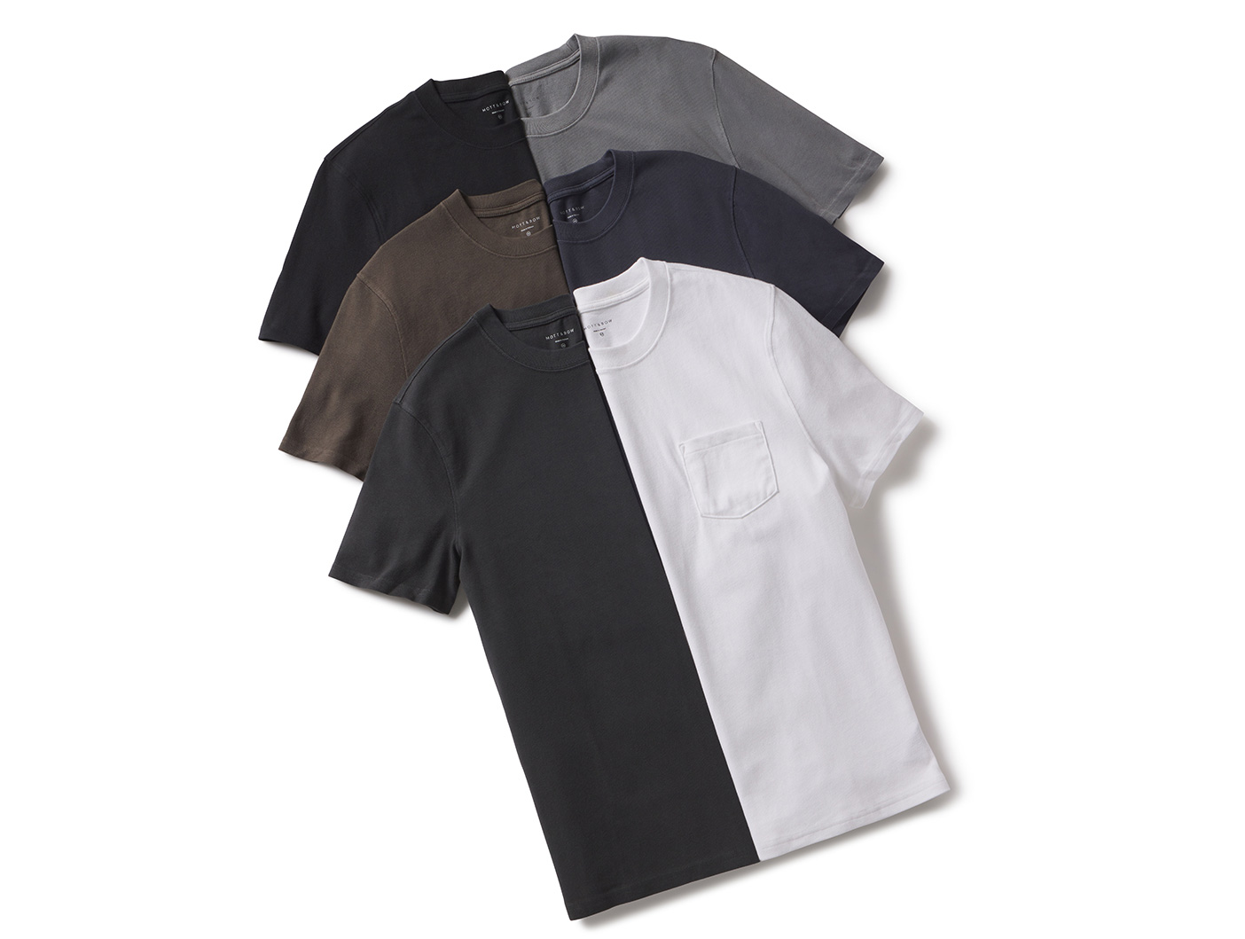 Five folded t-shirts in various neutral colors are arranged diagonally on a white background.