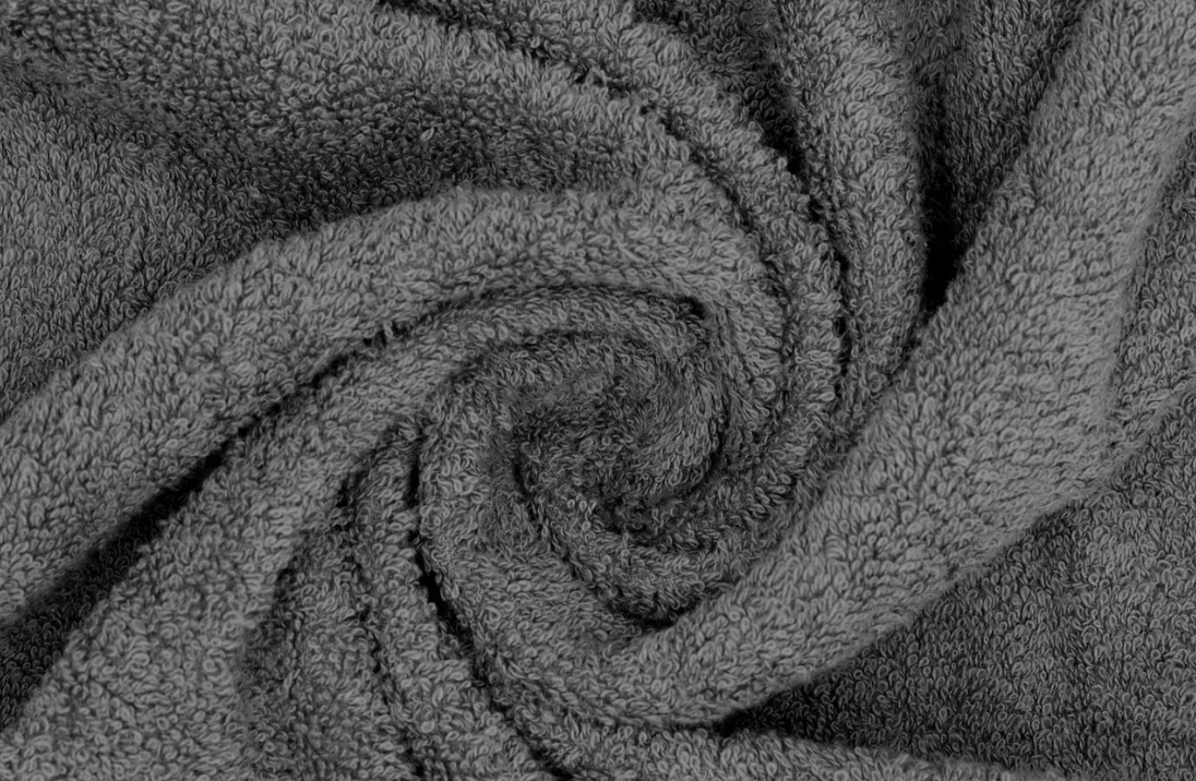 Close-up of a soft, grey, textured towel in a spiral pattern.