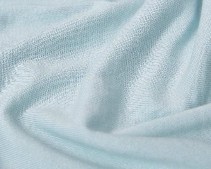 Close-up of light blue fabric with soft folds.
