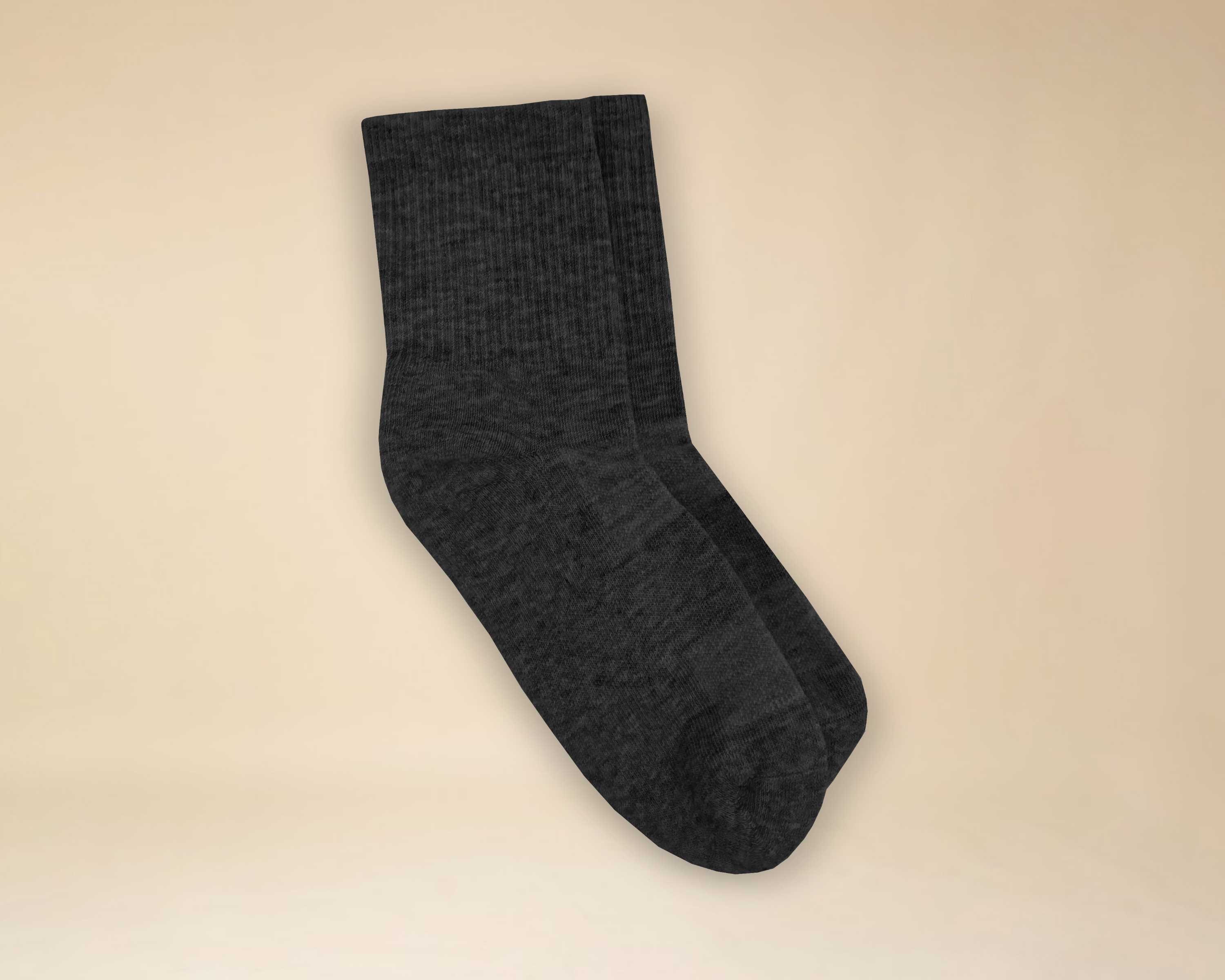 A pair of dark gray ribbed socks laid flat against a light tan background.