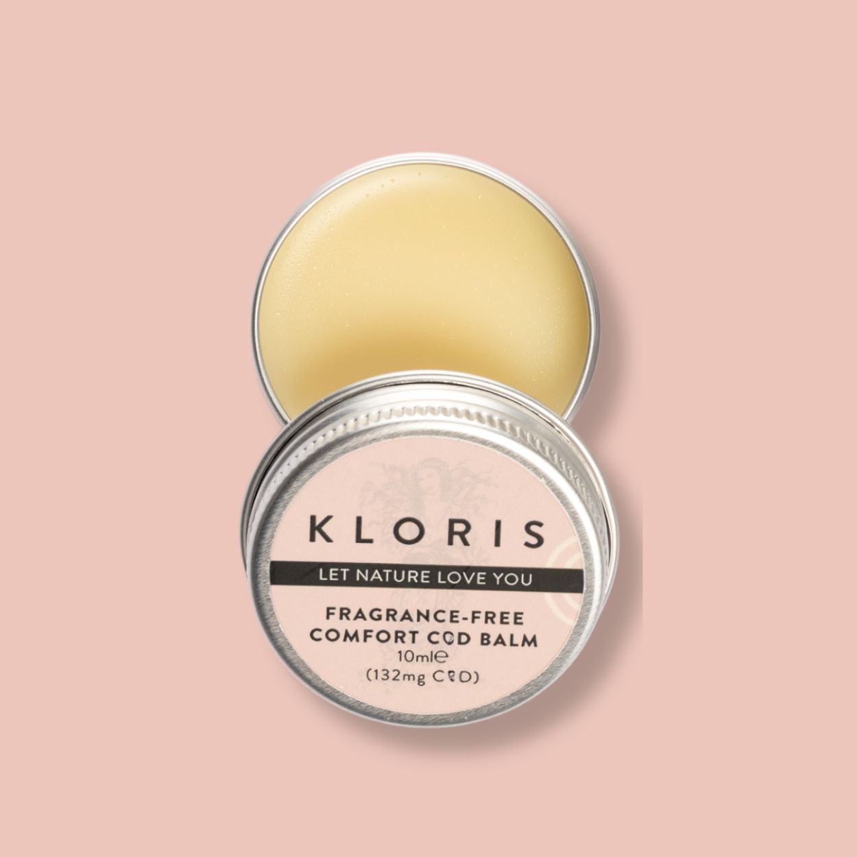 An open tin of Kloris Comfort Balm, with its lid off, against a pink background.
