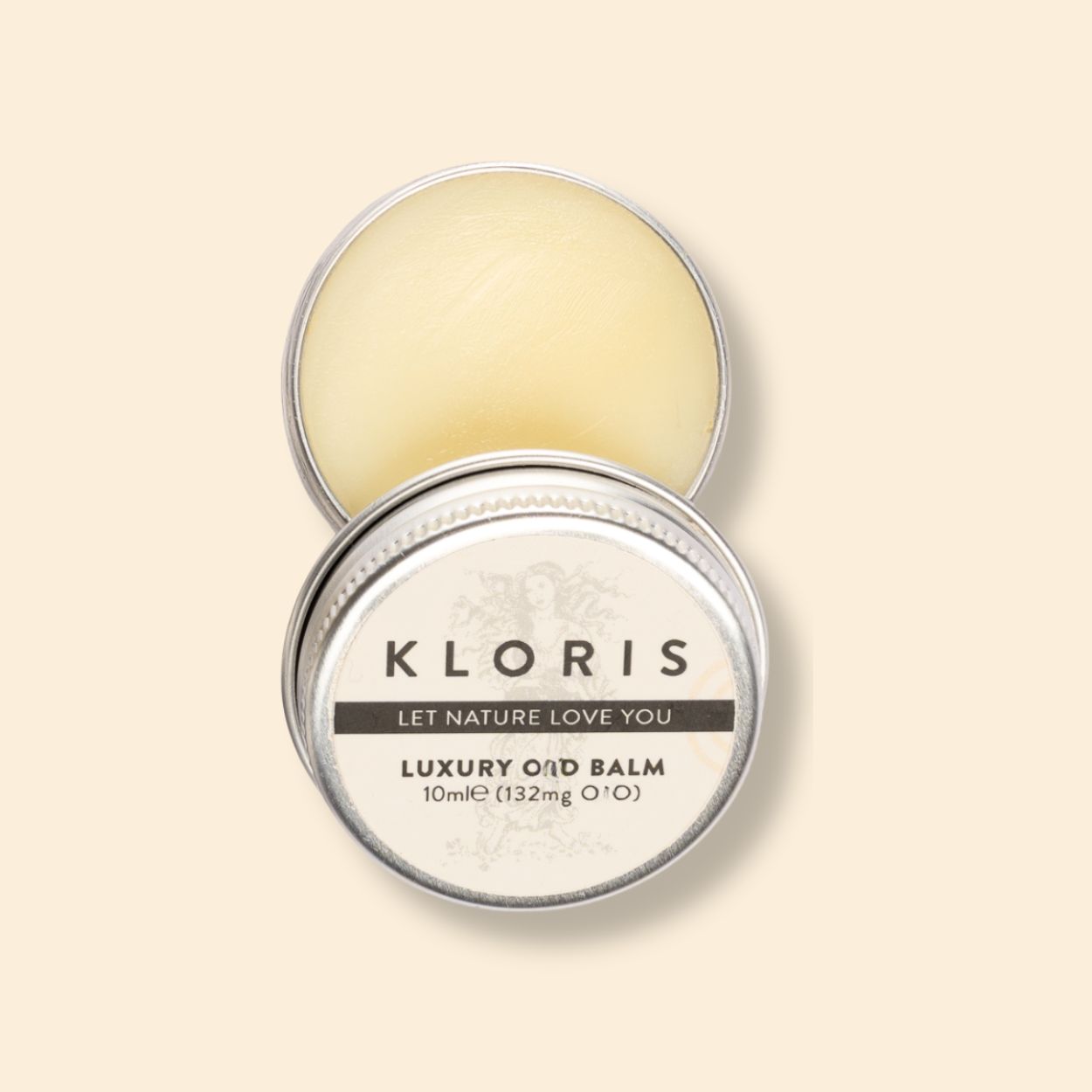 An open, round silver tin of Kloris Luxury Balm against a cream-colored background.