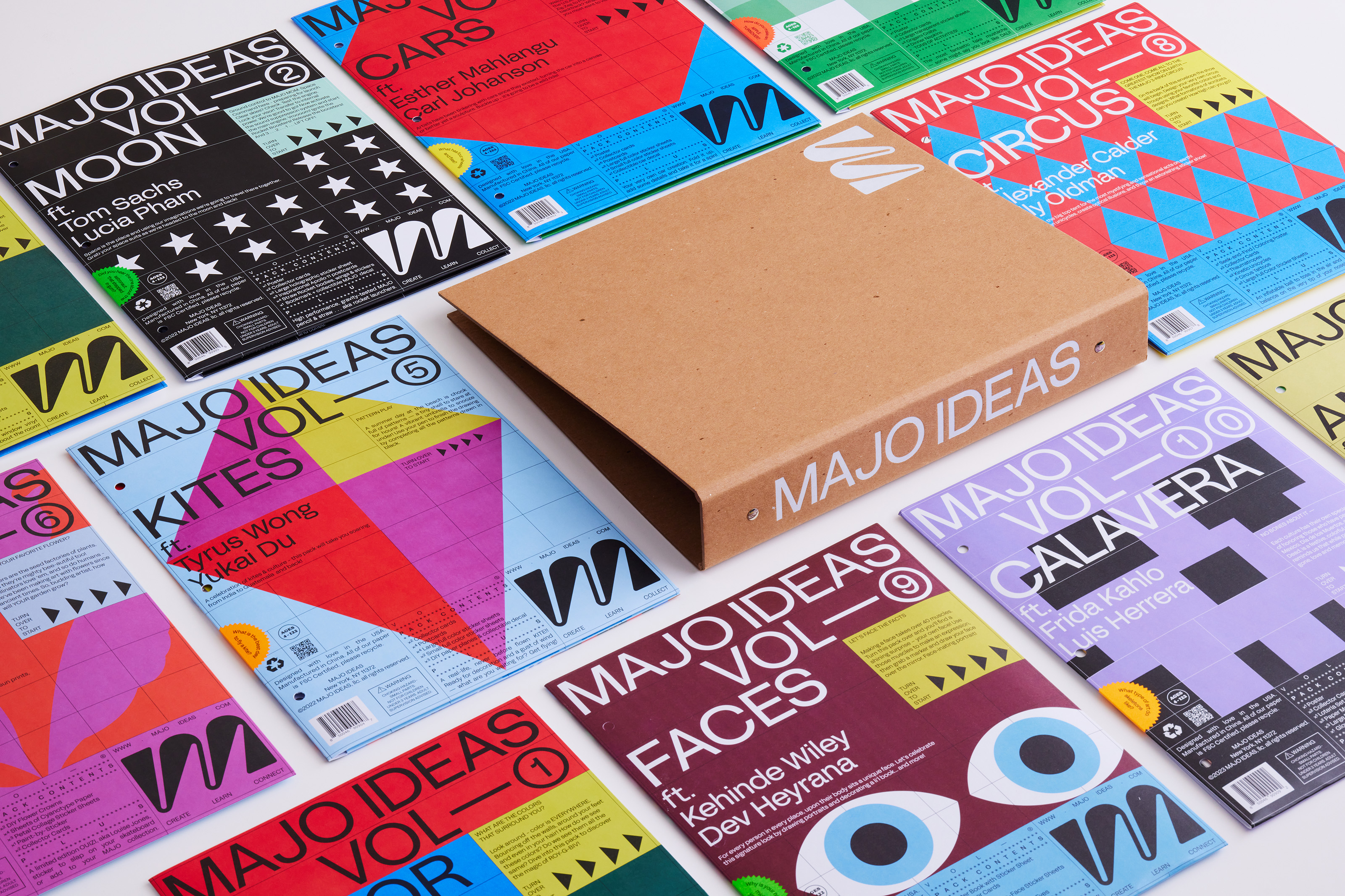 Colorful magazines titled 'MAJO IDEAS' arranged around a brown binder.