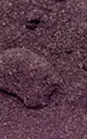 A close-up of a dark purple, granular, textured surface.