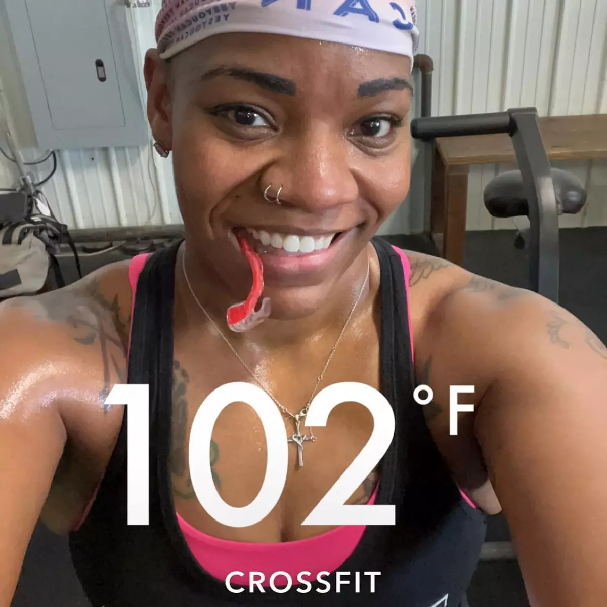 A smiling, sweaty woman in a gym takes a selfie with a mouthguard and text reading '102°F CROSSFIT'.