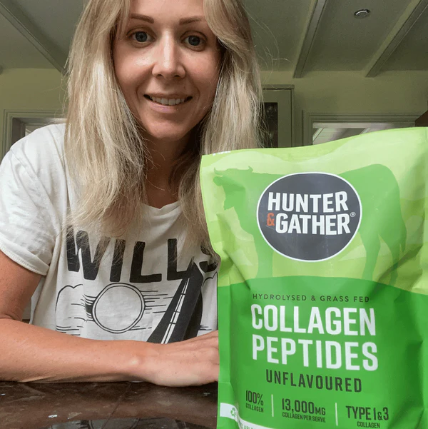 Person smiling next to a bag of collagen peptides.