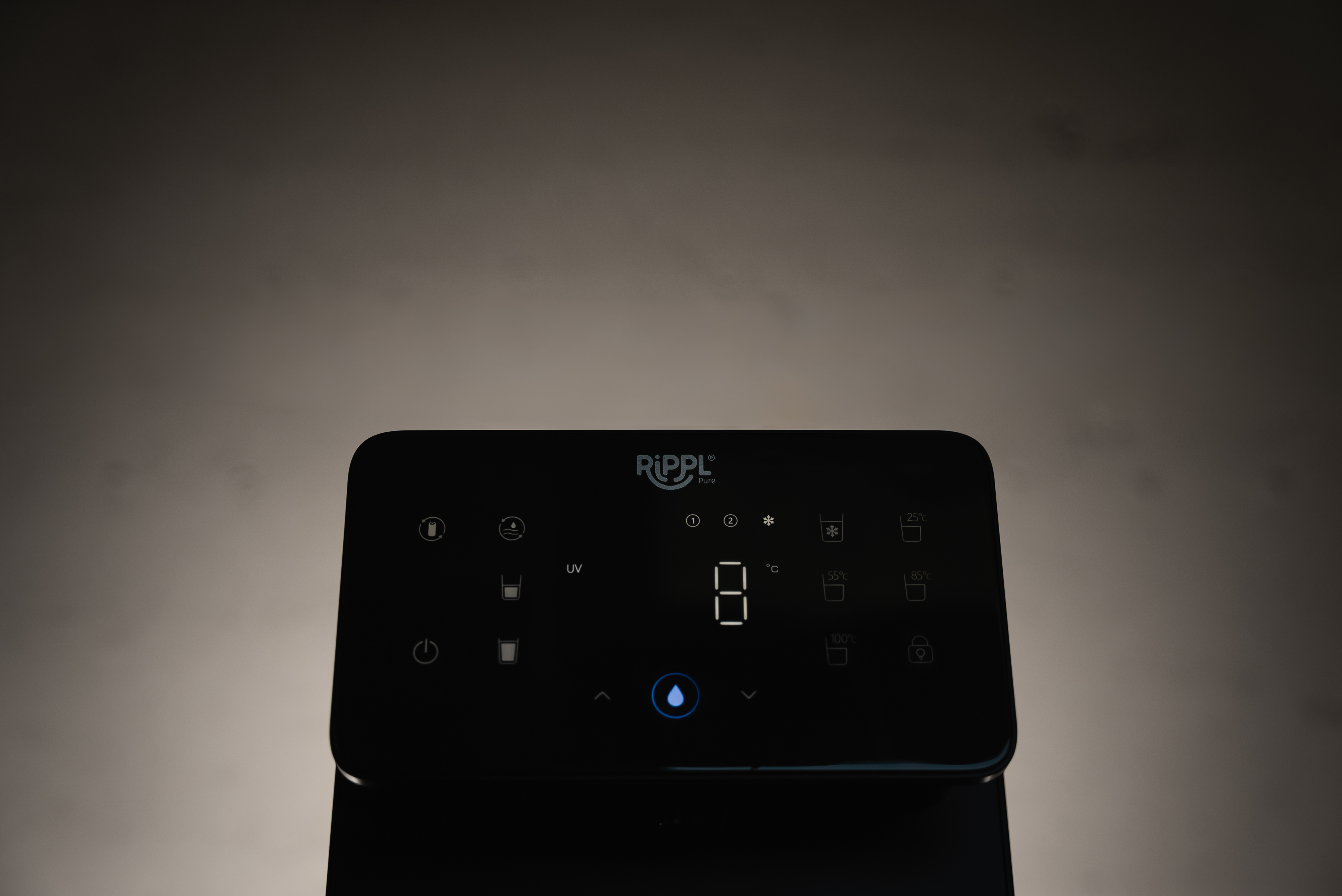 A close-up of the illuminated digital control panel of a black RIPPL Pure water dispenser.