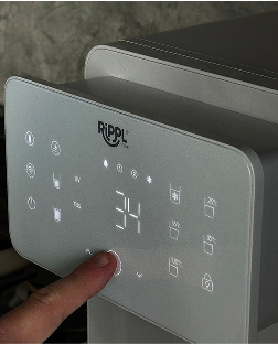 Person touching a digital control panel with illuminated buttons.