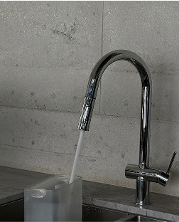 A modern chrome kitchen faucet filling a translucent container with water.
