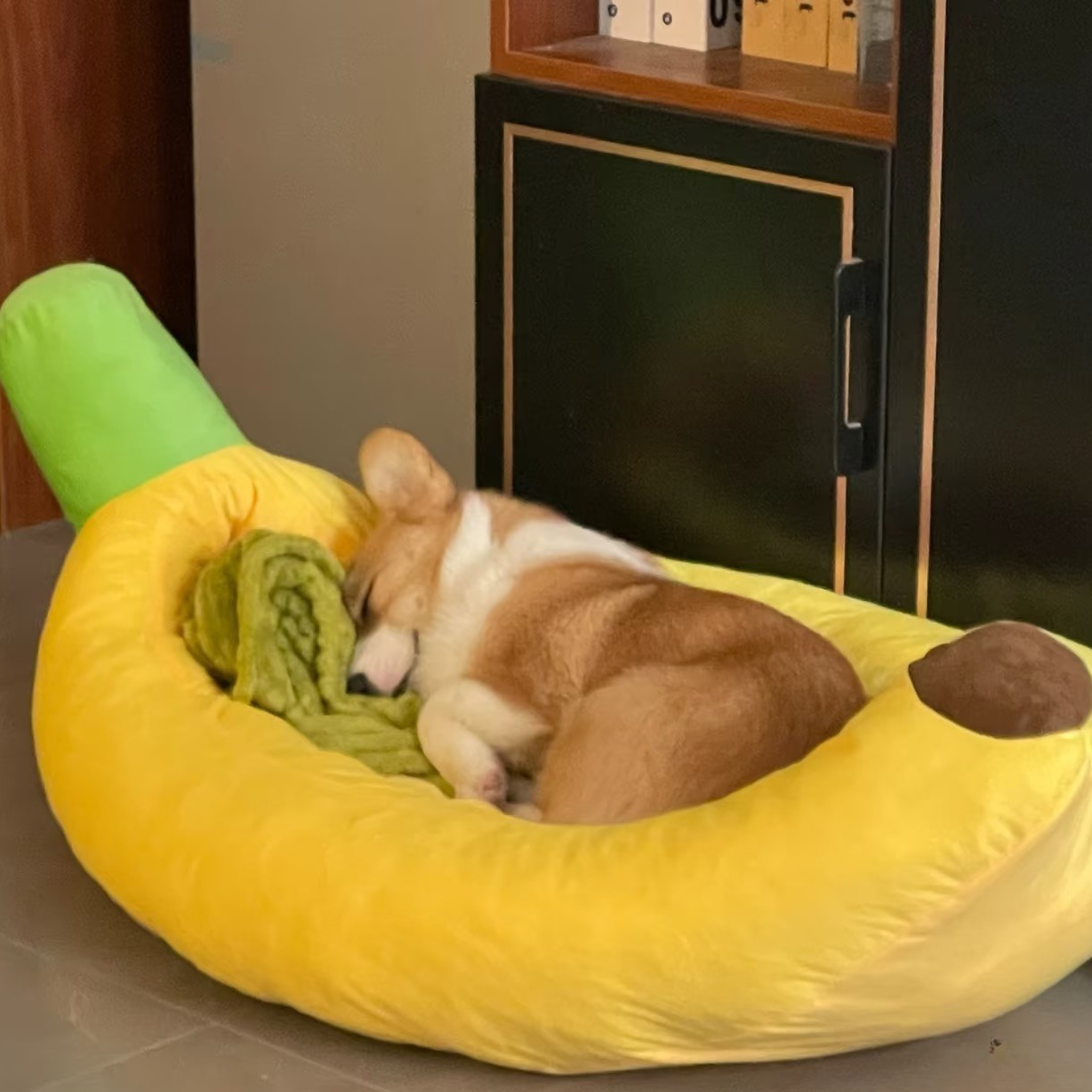 Dog sleeping in a yellow banana-shaped pet bed.