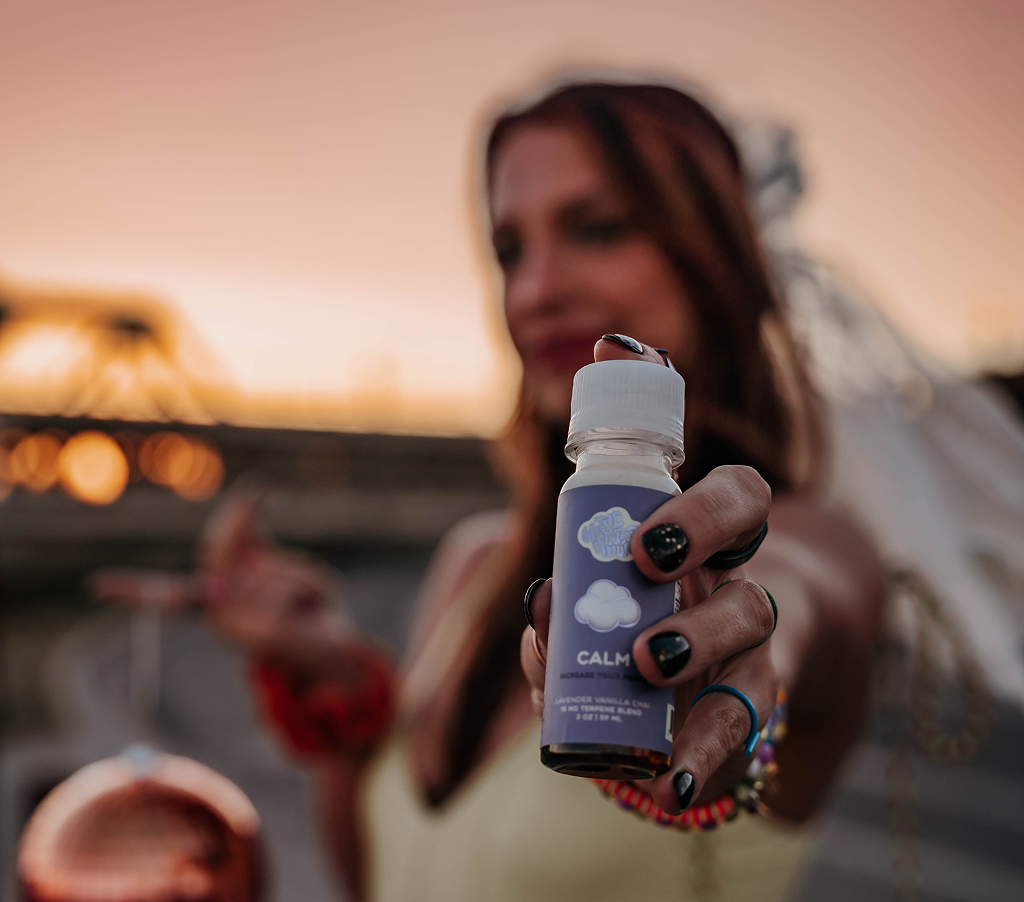 Person holding a small bottle labeled 'Calm' with a blurred background.