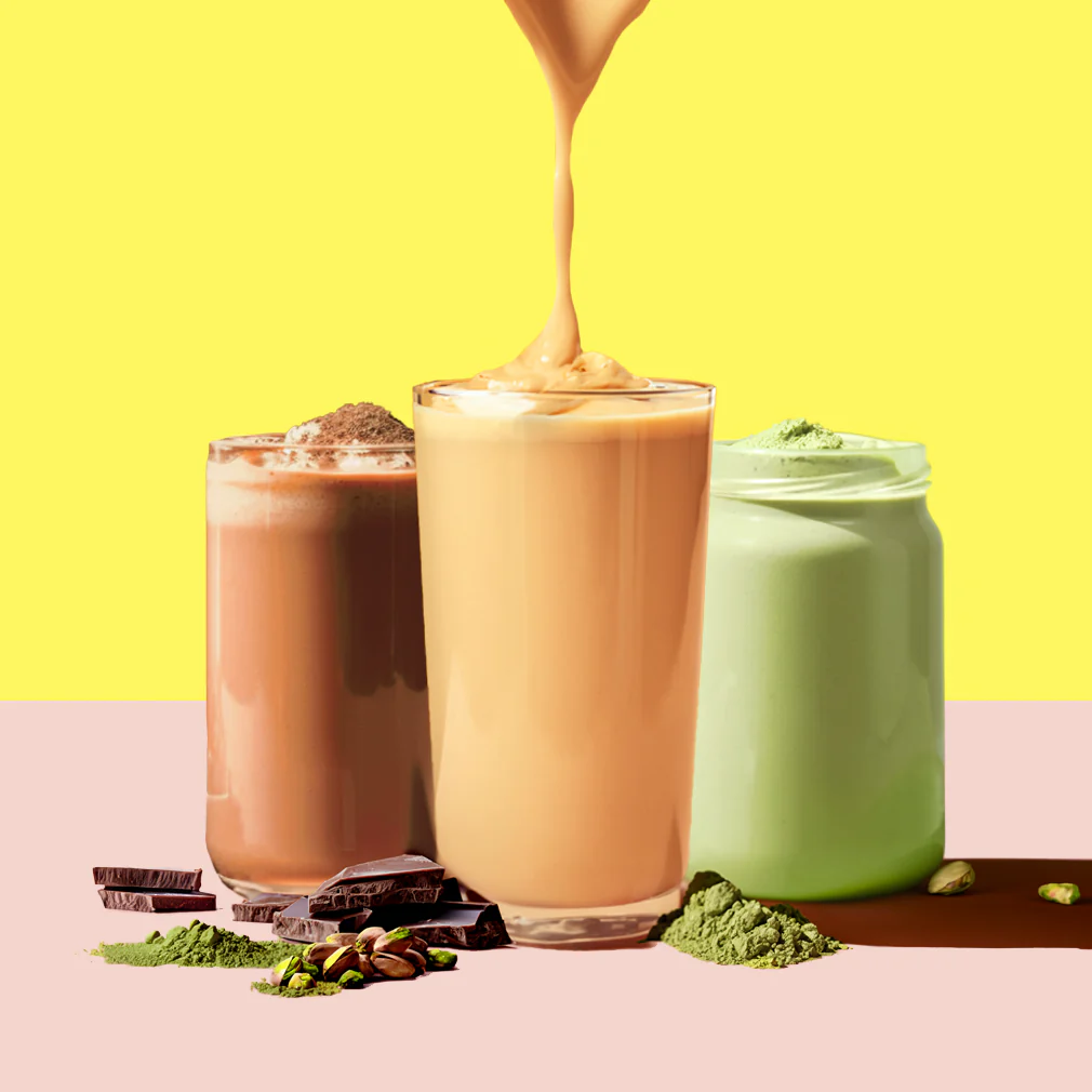 Three flavored shakes—chocolate, caramel, and pistachio—with their ingredients displayed against a colorful background.