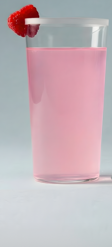 A clear glass of pink liquid with a single raspberry perched on the rim as a garnish.