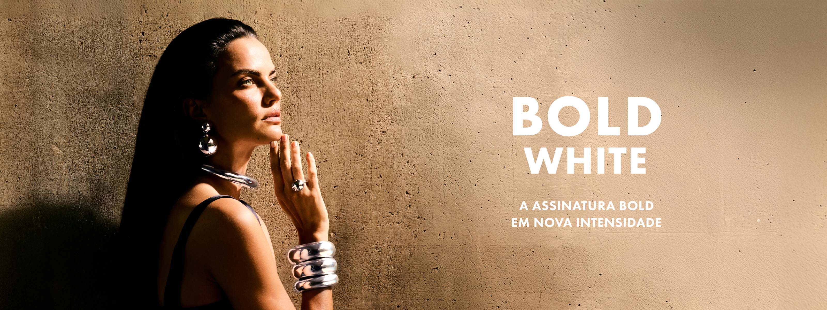 Mulher vestindo pulseiras, cuff, colar, brinco duplo e anel da coleção Bold White.