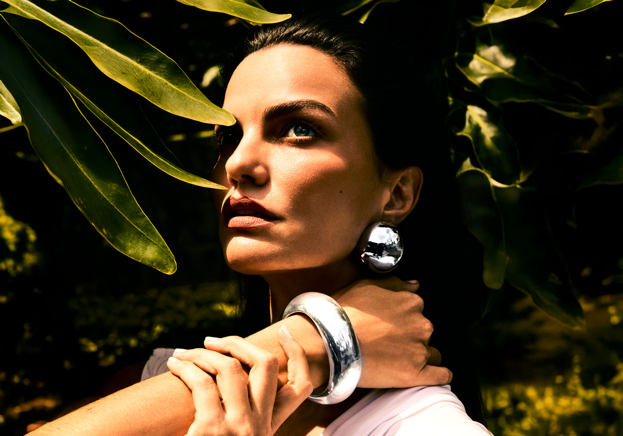 Mulher vestindo pulseira e brinco esfera da coleção Bold White