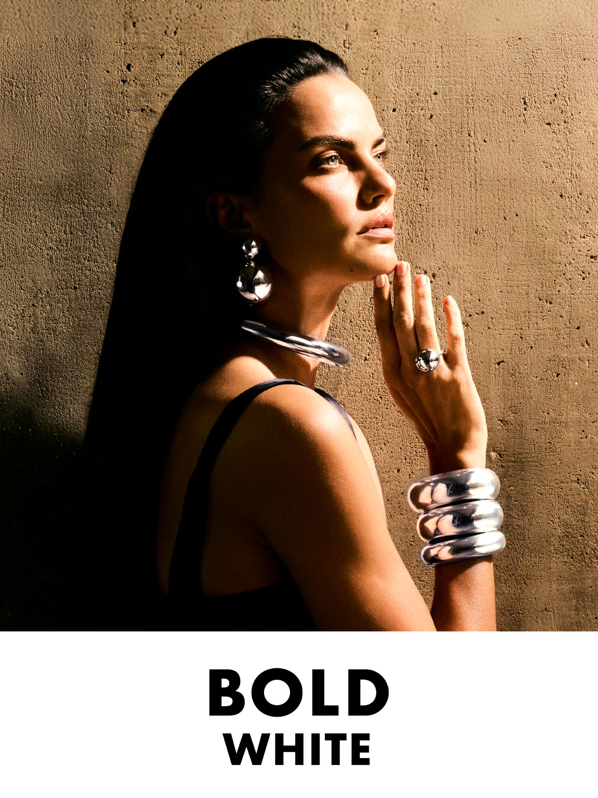 Mulher vestindo pulseiras, cuff, colar, brinco duplo e anel da coleção Bold White.