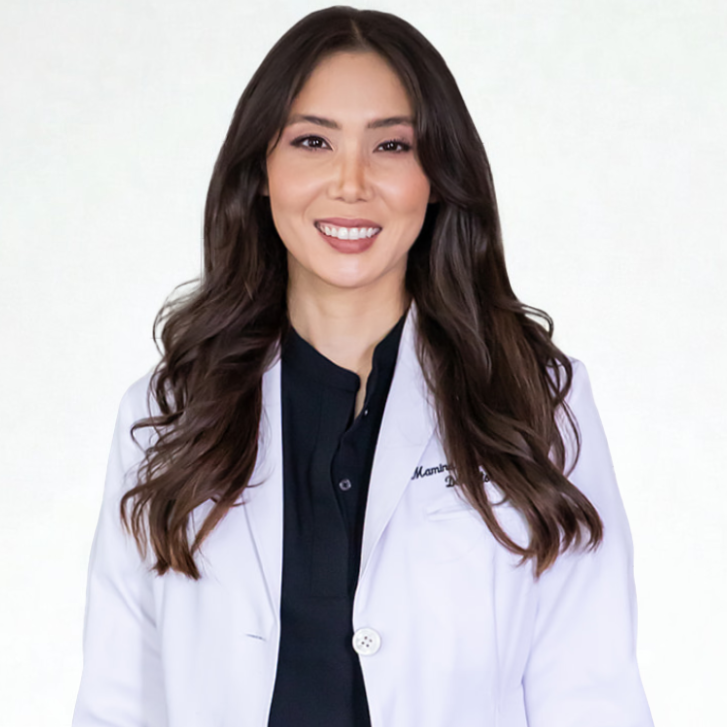 Person smiling in a white lab coat.